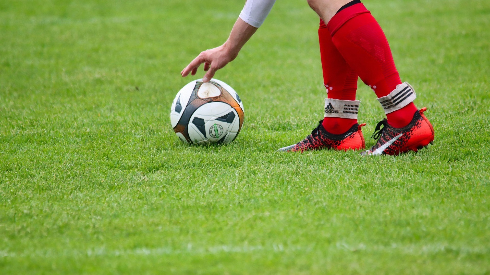 サッカーボールをフィールドに置く選手